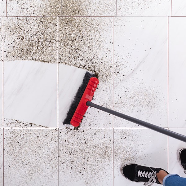 Broom cleaning dirt on tiled floor | Bud Polley's Floor Center